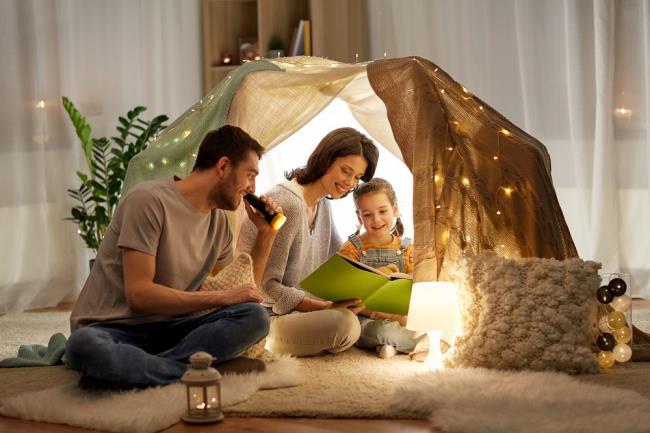 Unikaj stresu podczas pandemii koronawirusa Rodzina w domu z dzieckiem bawiącym się w namiocie Czytanie książek