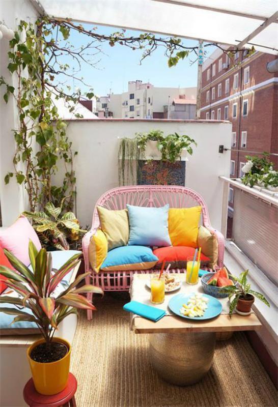 Taras gotowy na wiosnę, tworzy mały balkon, małe kanapy, okrągły stół, dużo kwiatów, kolorowe poduszki, wiosenna atmosfera