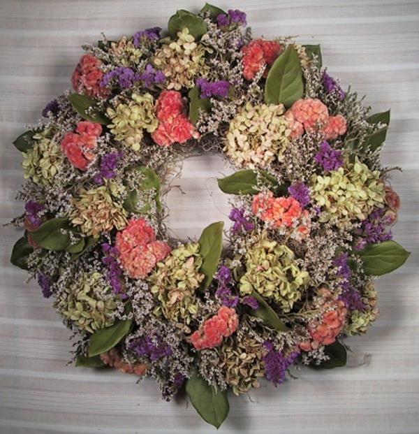 Couronne de porte avec des plantes aux couleurs pastel claires