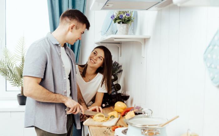 Tomber amoureux du signe du zodiaque Capricorne jeune couple cuisinant dans la cuisine