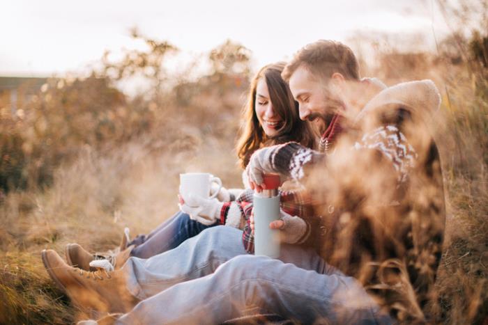 Jeune couple amoureux lors d'une randonnée en forêt passe joyeusement une pause-café dans la nature passe du bon temps ensemble