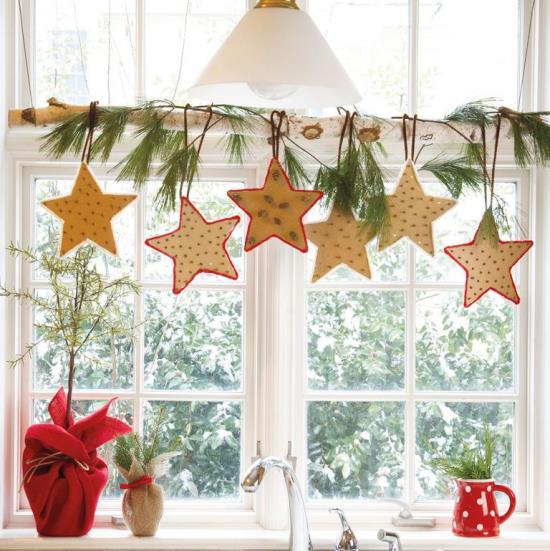 Świąteczna dekoracja okna Okna kuchenne zdobią gałęzie brzozy kolorowymi gwiazdami zwisającymi z zieleni jodły