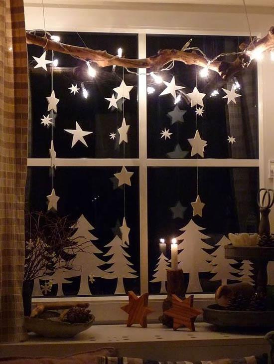 Świąteczna dekoracja okienna gwiazdki małe jodły wykonane z białego kartonu dobre oświetlenie wyglądają atrakcyjnie