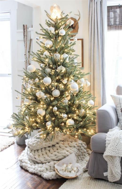 Le sapin de Noël décore de nombreuses petites lumières en boules de sapin de Noël brillantes blanches et argentées