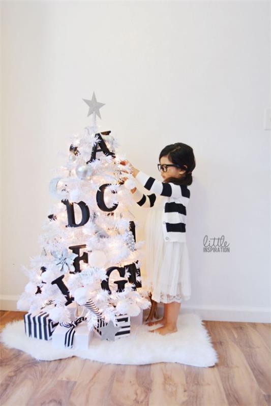Sapin de Noël décorer en blanc et argent petit sapin en décor blanc en contraste noir grosses lettres petite fille