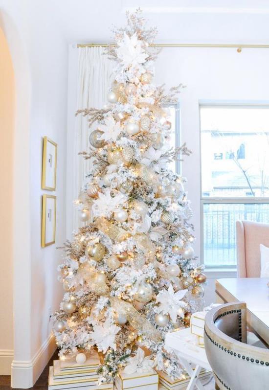 Sapin de Noël décorer un sapin de Noël joliment décoré en blanc et argent, y compris des cadeaux qui attirent l'attention dans la pièce