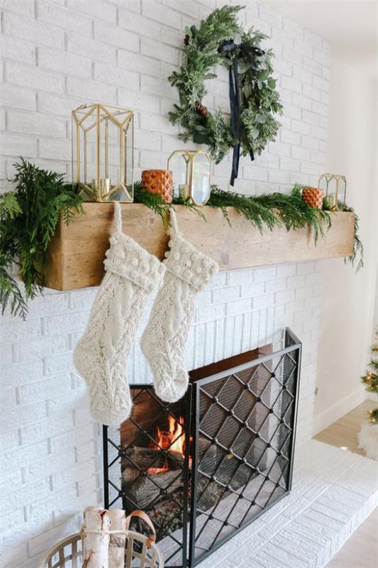 Décoration d'hiver dans le salon au coin du feu bas Père Noël blanc sapin vert comme une guirlande bougies guirlande de lanternes sur le mur