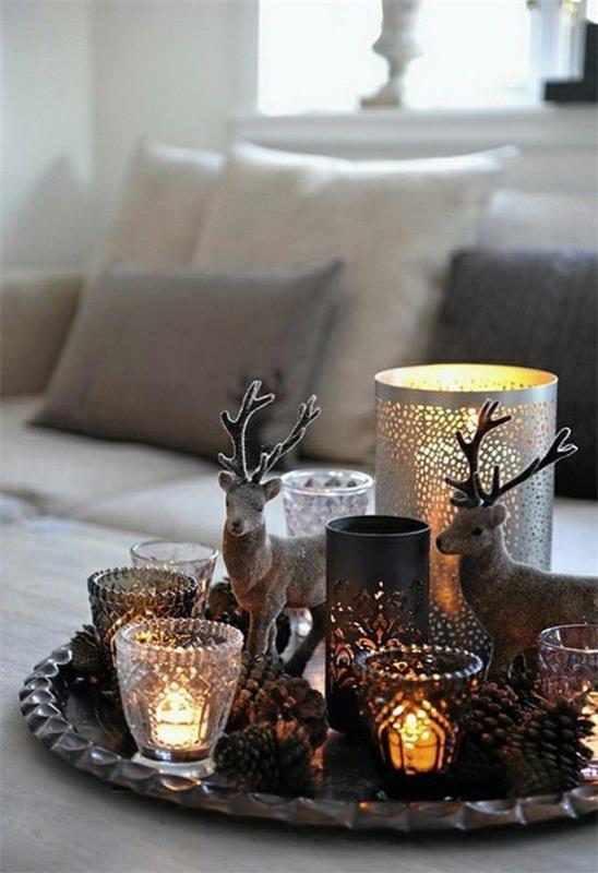 Décoration d'hiver dans le salon, des bougies magistralement disposées allument des figurines de Noël sur la table basse