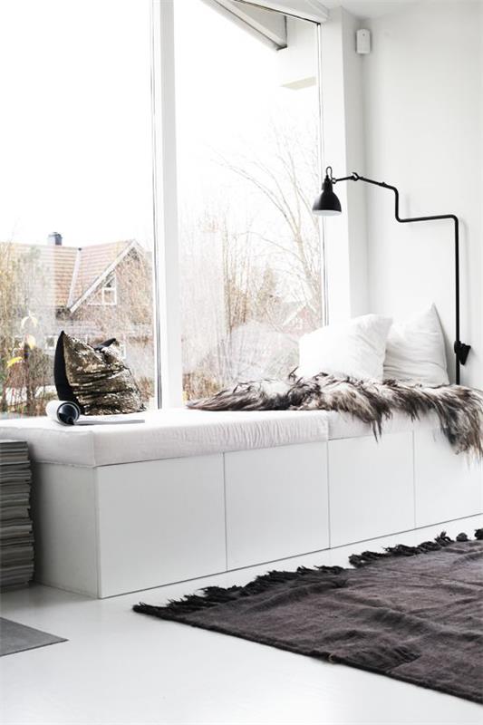 Décoration d'hiver dans le salon coin de fenêtre ensoleillé pour se détendre contraste oreillers moelleux blanc-noir tapis de fourrure câlin
