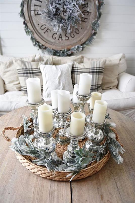 Décoration d'hiver dans le salon, des bougies blanches dans un panier en osier plat disposées avec un peu de brillance et de paillettes sont un véritable accroche-regard