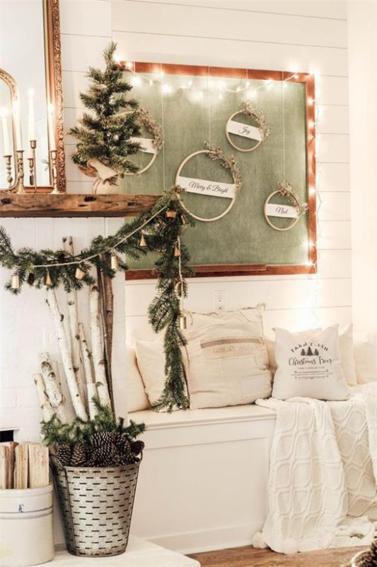 Décoration hivernale dans le salon, banc blanc à côté de la cheminée, décoré de choses simples, quelques pommes de pin vertes dans le seau