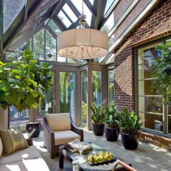 Jardin d'hiver pour se blottir merveilleusement atmosphère invitante beaucoup de soleil lumineux meubles confortables beaucoup de plantes vertes dans des pots lampe suspendue