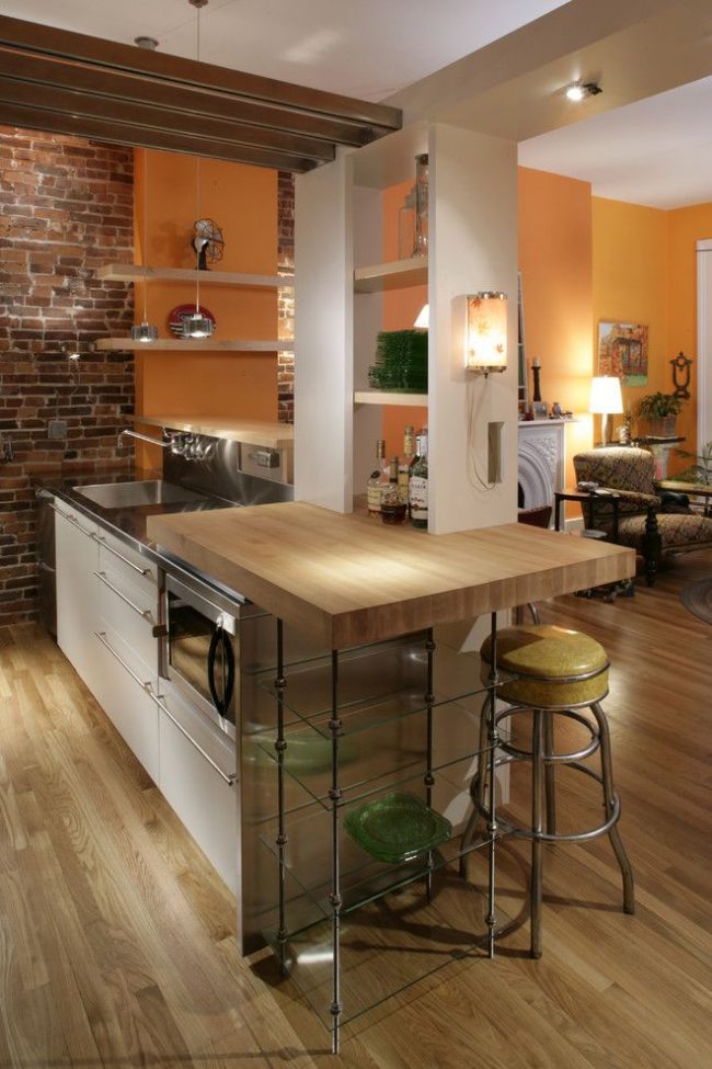Kücheninsel mit originellem Design. Die Bartheke besteht aus einem Essbereich und einem zusätzlichen Arbeitsplatz. Eine Holztischplatte für einen Essbereich und eine Metallplatte für einen Arbeiter. Zum Design gehört auch eine funktionale Gipskartonnische mit Regalen