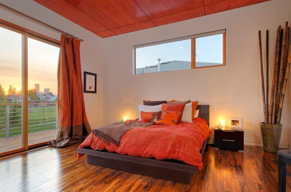 fajna paleta kolorów sypialni akcentowana pomarańczowymi narzutami