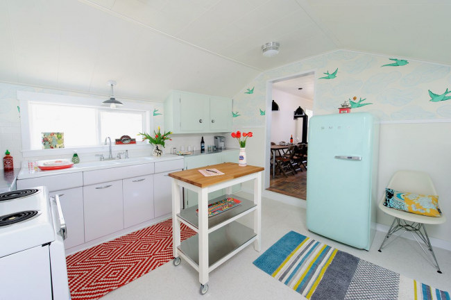 Деликатен хладилник в светлосин нюанс в малка кухня, зонирана с цветни акценти