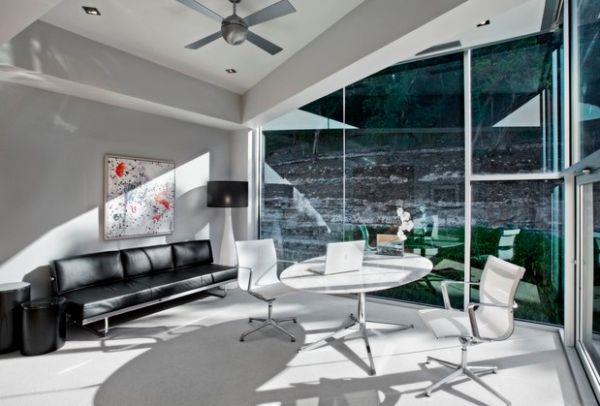 designerskie biuro okrągły stół biała sofa okno światło