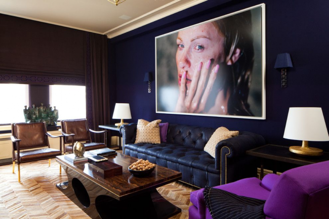 Moderní obývací pokoj v tmavých barvách s tmavě modrou pohovkou Chesterfield