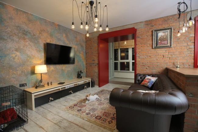 Obývací pokoj ve stylu podkroví s cihlovou zdí a koženou sedací soupravou Chesterfield