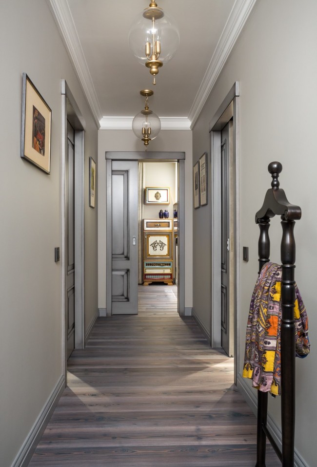 Тесен коридор в неутрални светли цветове е идеален за комбиниране на разнообразни стаи в апартамент