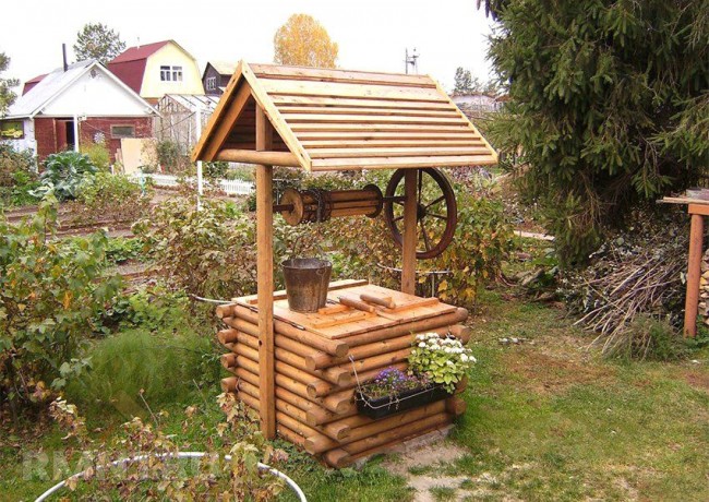 Ein Holzhaus für einen Brunnen wird auf einem Sommerhaus gut aussehen