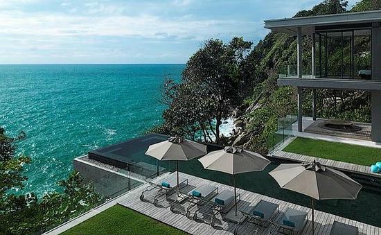 maison de vacances sur la terrasse ensoleillée de la plage avec chaises longues et parasols