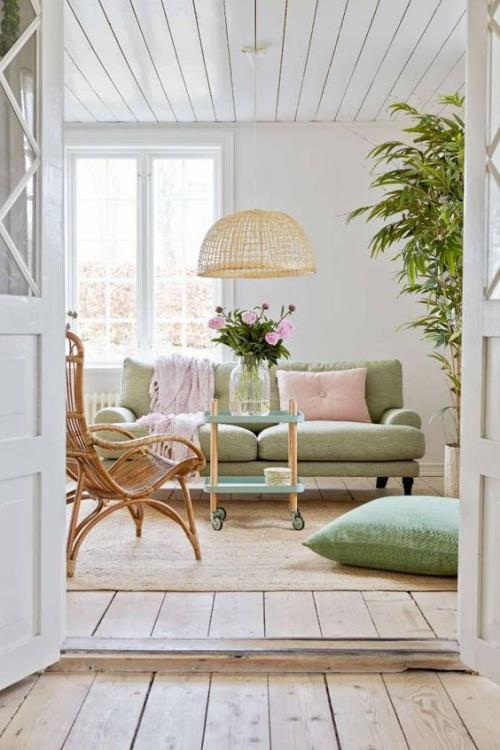 idées de décoration printanière pour le salon meubles rembourrés en vert pastel doux rose clair coussins de couverture roses roses dans un vase sur la table