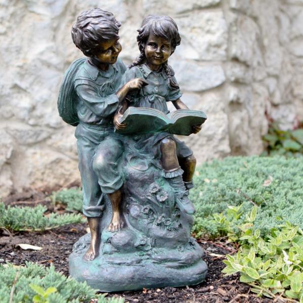 garçon de statue en forme de jardin lisant