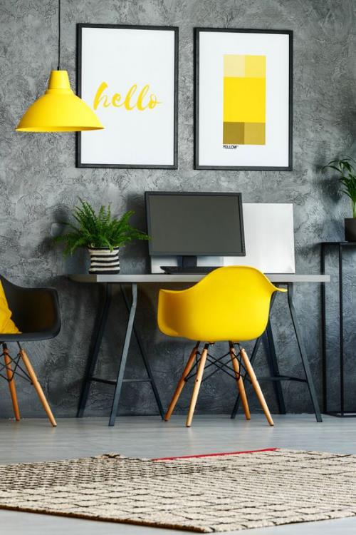 accents jaunes dans le bureau à domicile inspiration de bureau papier peint gris mur fauteuil jaune lampe suspendue jaune pot de fleur peintures murales PC