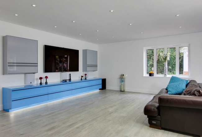 Prostorný obývací pokoj s lesklým nábytkem v chladných barvách