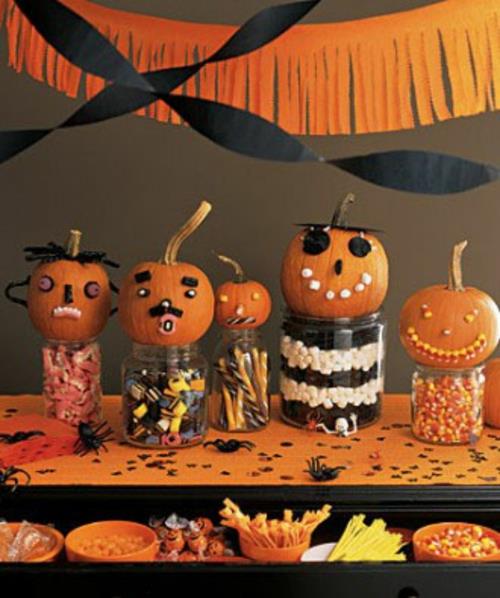 halloweenowe słoiki do dekoracji stołu z cukierkami i mini dynie z twarzami