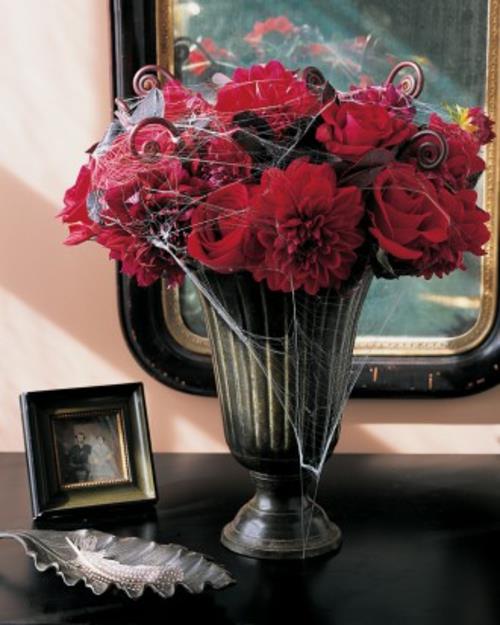 halloweenowe dekoracje stołu czerwone róże i dalia z pajęczynami