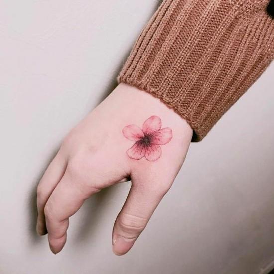 petit tatouage de fleur de cerisier à la main