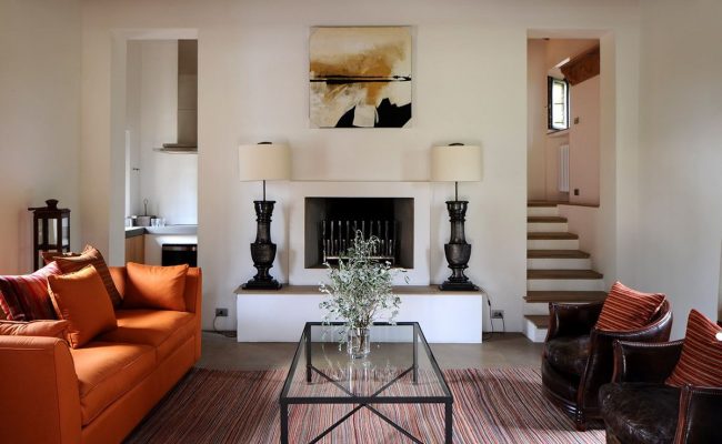 Контрастът на ярко оранжев диван и кафяви кресла е присъщ на средиземноморския стил.