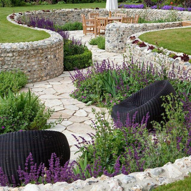 Gartenweg und Sitzplatz mit einer mit Wildstein verkleideten Stützmauer