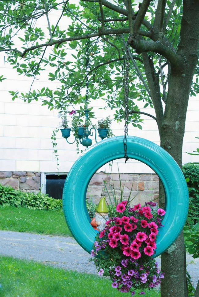 Sázecí stroj na květiny z pneumatiky zavěšené svisle na stromě je jednoduchý a účinný způsob, jak ozdobit území domu