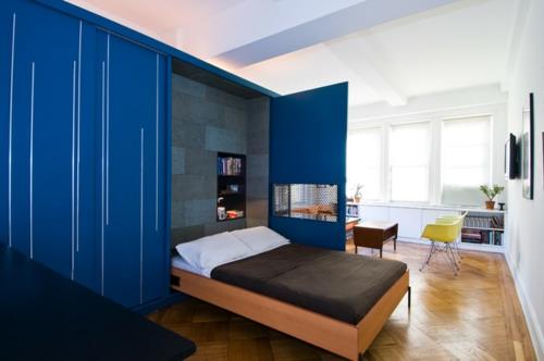 Un petit appartement conçoit un cadre en bois coulissant pour lit double intégré