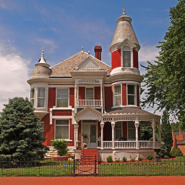 Ярко червена и бяла къща с малка кръгла жилищна кула