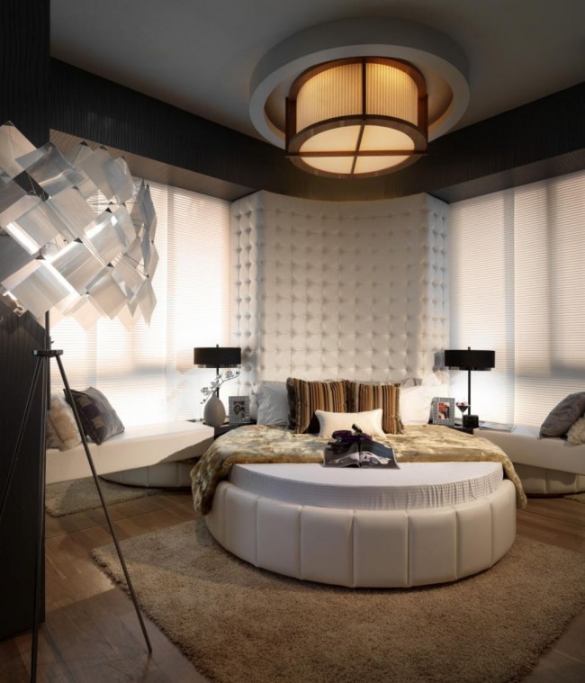 Zeitgenössisch + glamourös: ein halbrundes hohes weiches Kopfteil in Weiß und ein weißes Bett umgeben von neutralen und natürlichen Farben