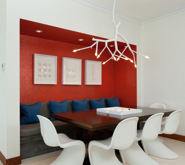 مطبخ أبيض متوسط ​​مع لمسات حديثة: مكانة حمراء ساطعة وضوء معلق ملفت للنظر