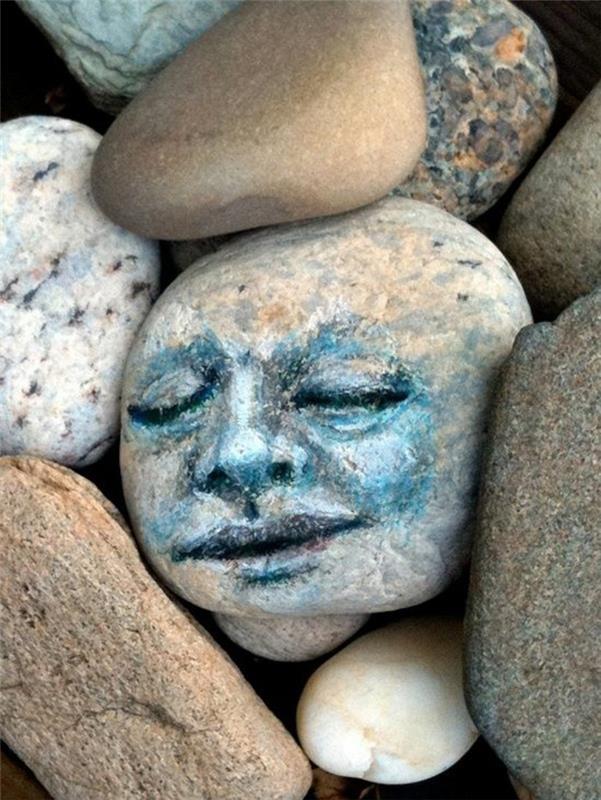 sztuka z kamieniami malującymi twarz na kamieniu rzecznym