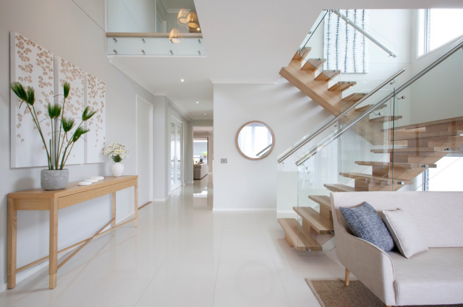 Zweiläufige Treppe mit Holzstufen und Geländer aus Glas und Metall