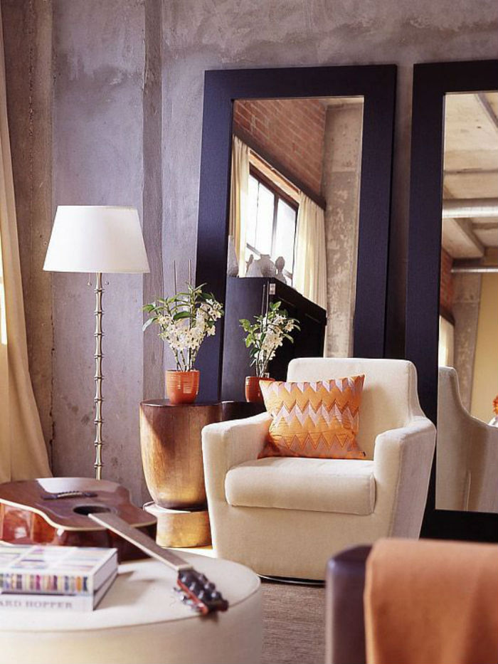 غرفة معيشة أصلية بألوان الباستيل اللطيفة مع مرايا كبيرة تساعد على تكبير المساحة بصريًا حتى في غرفة صغيرة جدًا