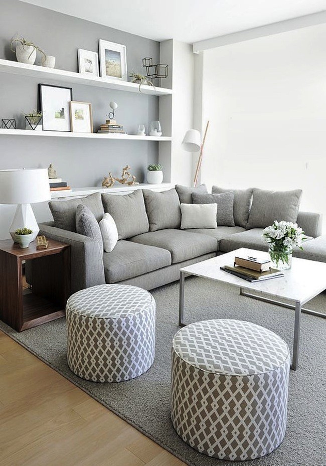 Světlý obývací pokoj v bílých a šedých tónech s jasným akcentem na původní dřevěnou skříňku u sedačky