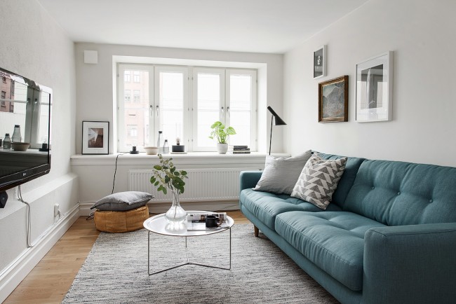 Skleněný konferenční stolek vytváří lehkost v interiéru malého obývacího pokoje