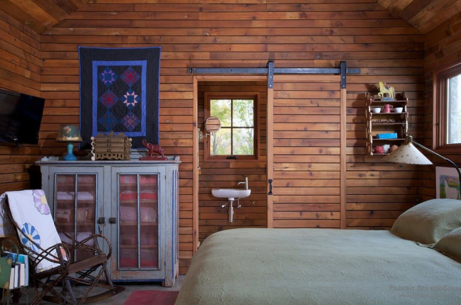 غرفة نوم منزل ريفي ذات أجواء رائعة مع باب خشبي منزلق