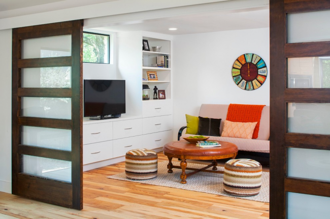 Kombinierte Innenschiebetüren aus Naturholz und Milchglas ergänzen das Wohnzimmer im skandinavischen Stil perfekt