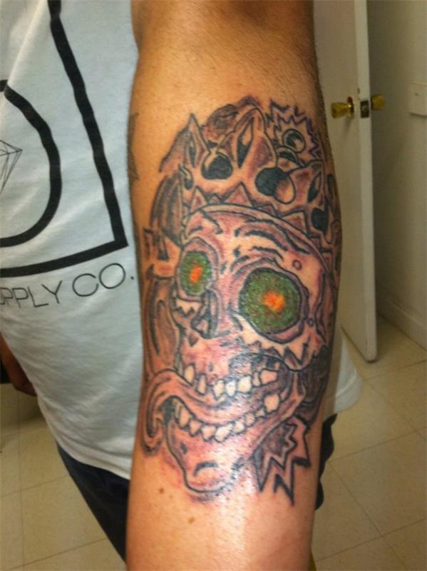 tatouage idées bras crâne yeux verts