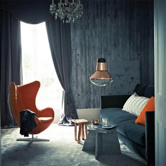 fauteuil orange confortable papier peint en béton d'origine lampe suspendue lustre rideaux gris classiques