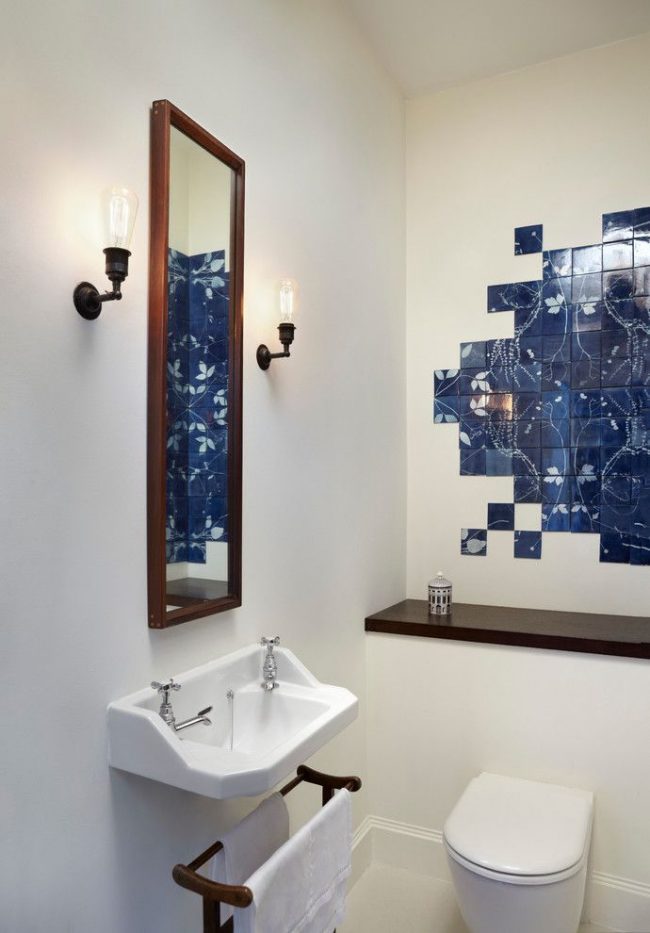 Ein Panel aus dunkelblauen Fliesen kontrastiert vor dem Hintergrund eines weißen Badezimmers