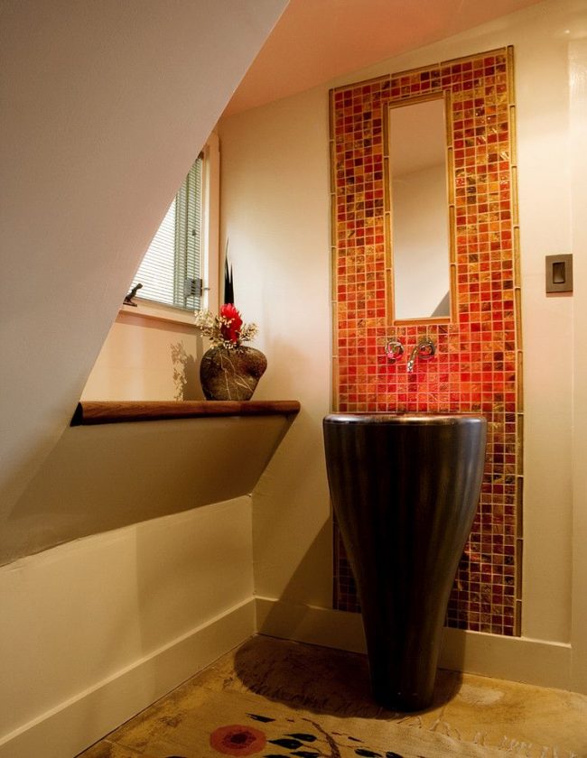 Schmale Mosaikplatten heben den Waschtischbereich im Bad hervor